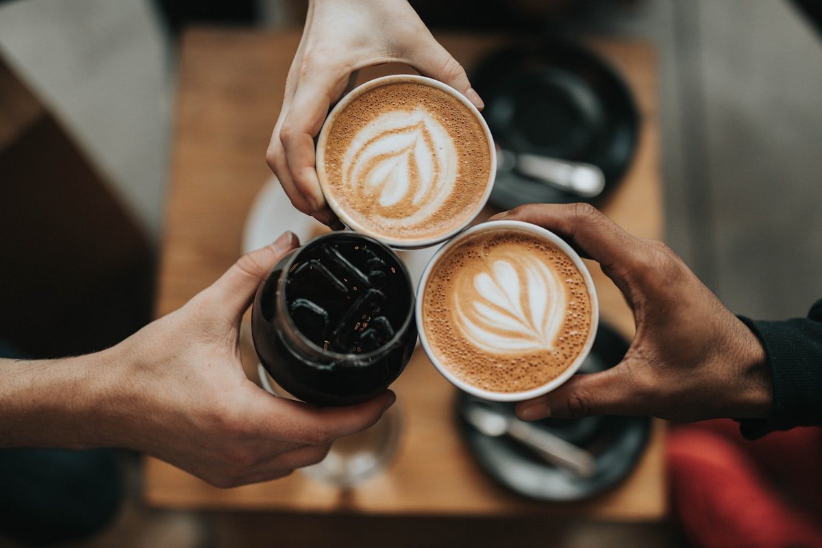 Two people talking across a small table in a bright cafe